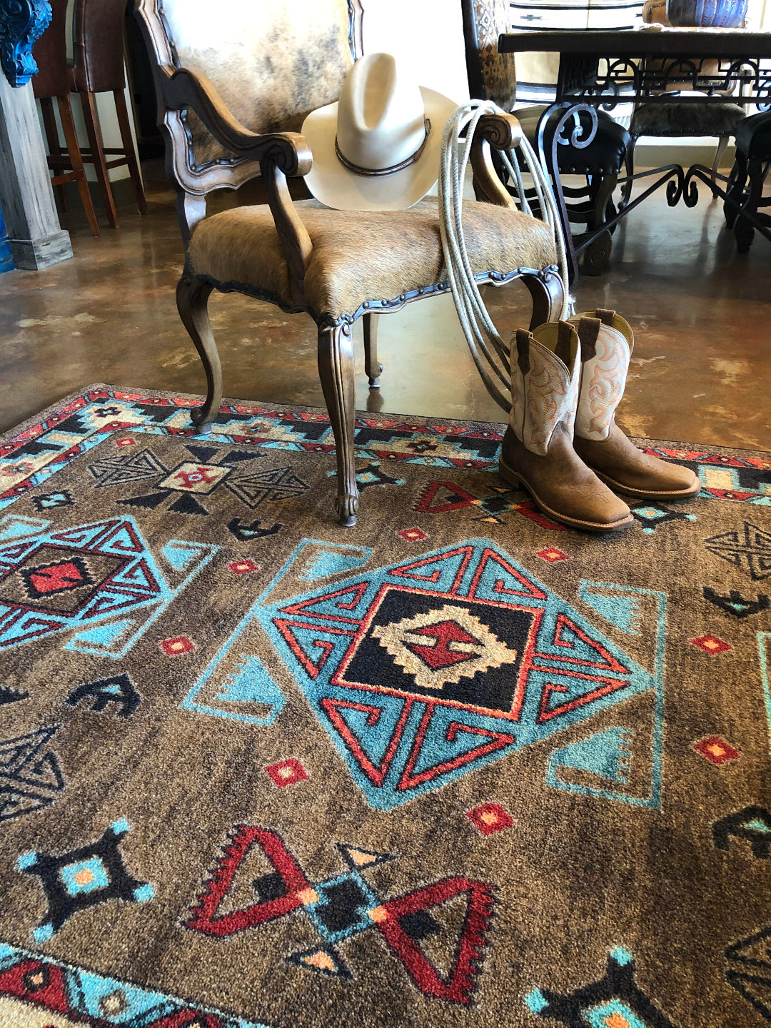 Saddle on a patterned rug with a chair in the background