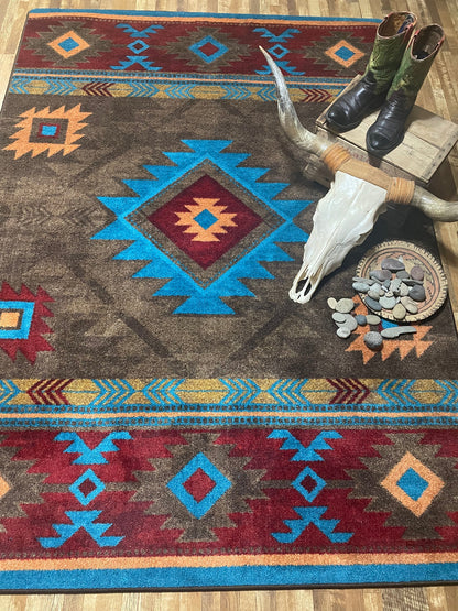 Decorative rug with Native American patterns and a deer skull on a wooden floor.