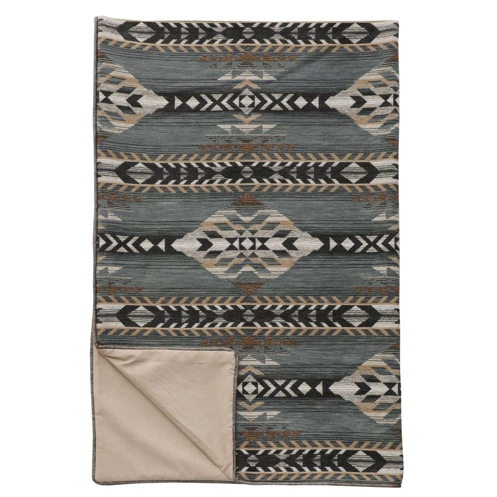 A patterned throw with geometric designs, predominantly in shades of gray and green, with a solid beige border at the bottom.